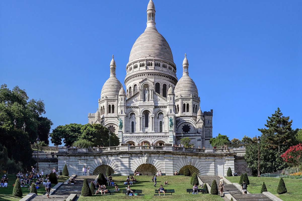 The Sacré-Cœur basilica in Montmartre, Paris, under a blue sky