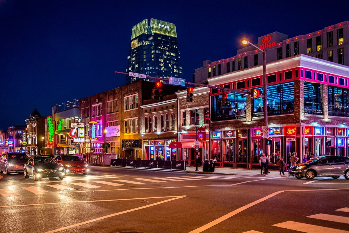 Neon signs and music venues illuminate Broadway in Nashville at night