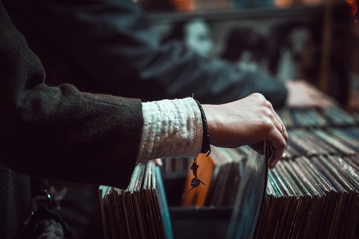 A person browsing tightly packed vinyl records in a shop