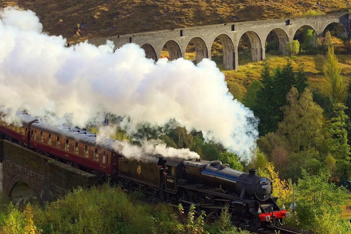 A steam train crosses the curved Glenfinnan Viaduct in Scotland