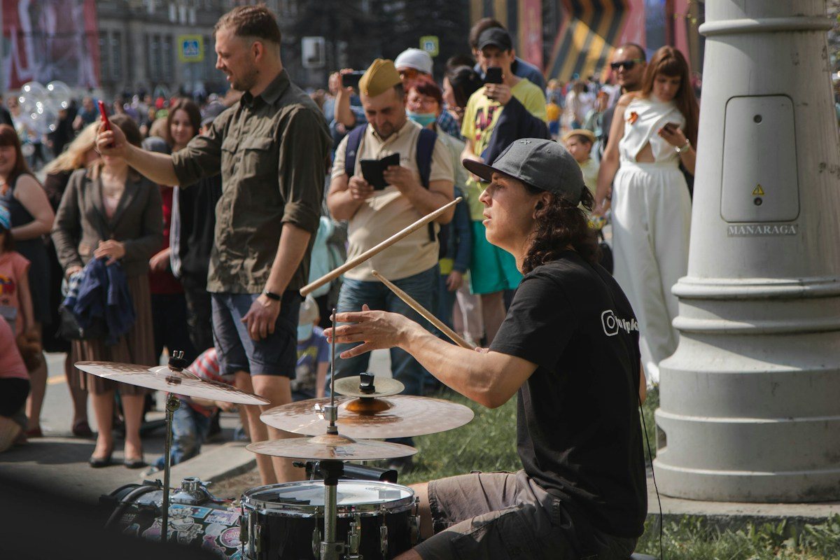 A drummer plays a compact kit for a crowd outdoors