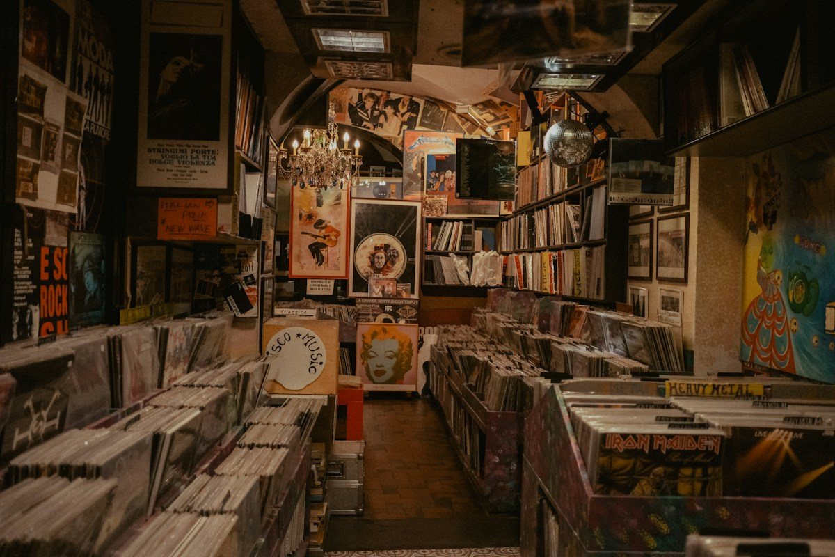 A narrow record store aisle lined with shelves and album covers