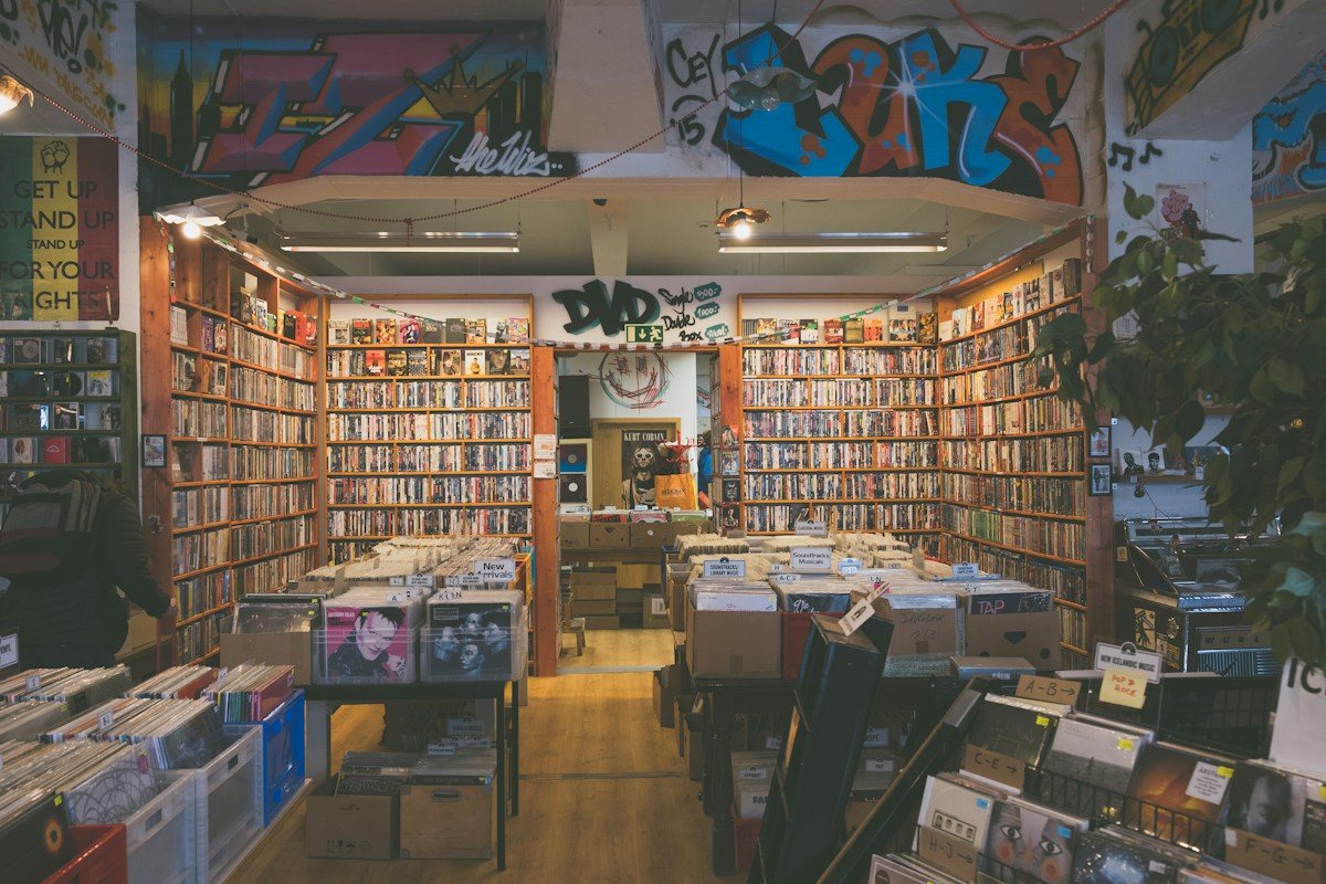 Music racks inside a shop with graffiti above the entrance