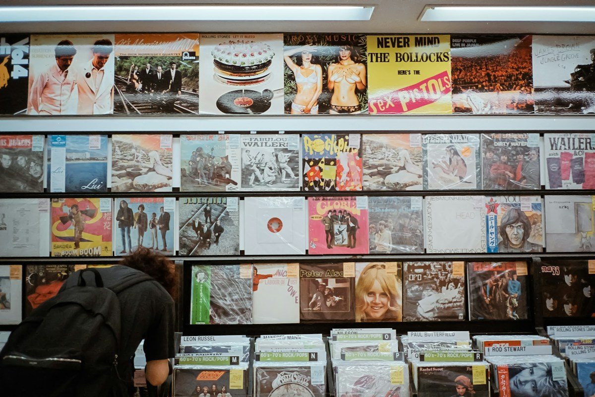 A shopper looks through records beneath a wall of album sleeves