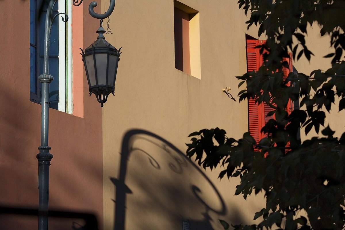 A street lamp casts a shadow on a colorful wall in Caminito, Buenos Aires